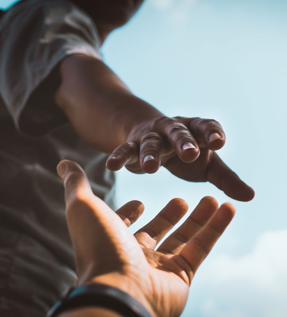 Help Concept hands reaching out to help each other in dark tone.